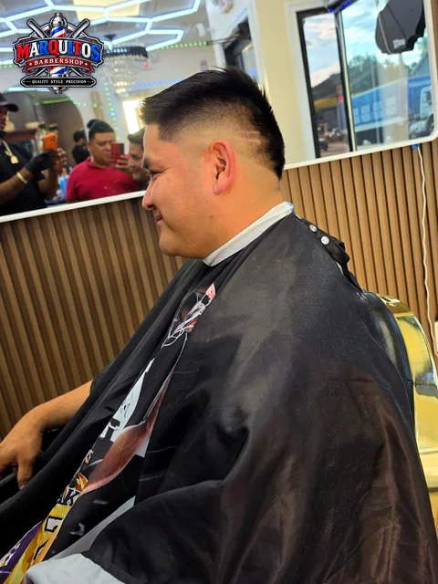 Smiling client with a fresh high fade and a shaved line, side view